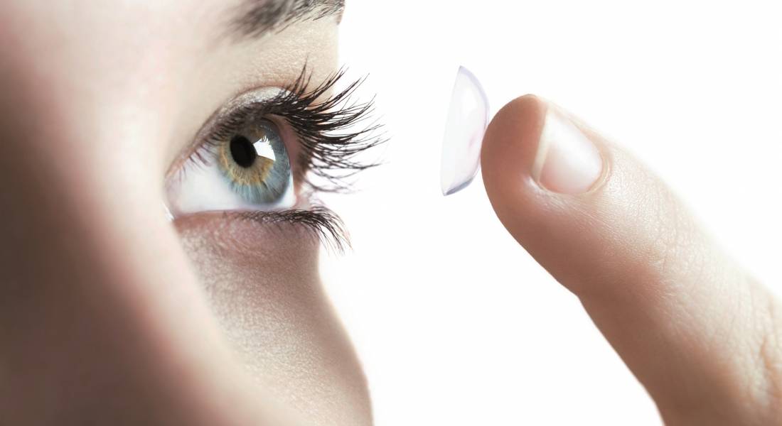 Contact lens use. Woman putting in a contact lens. --- Image by © Science Photo Library/Corbis